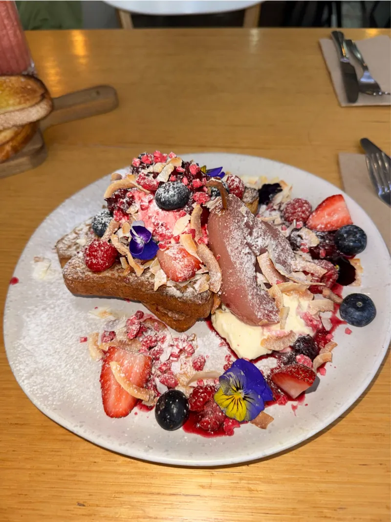 Brioche French toast with berries, poached pear and edible flowers