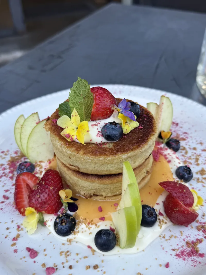 Pancake stack with fresh fruit and edible flowers